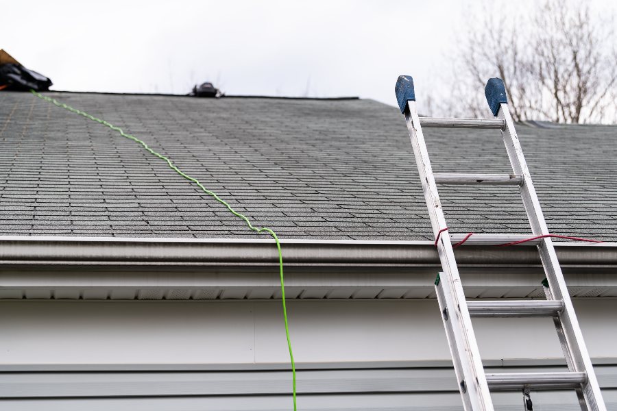 A man performing roof work on a house, inspecting the roof in South Florida
