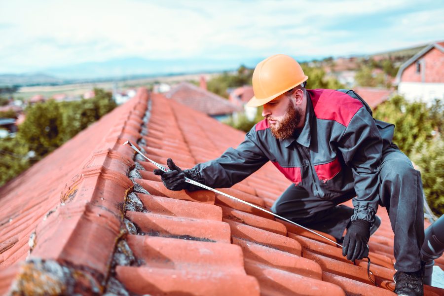 A Technician is Inspecting and Measuring the Roof for Replacement in South Florida