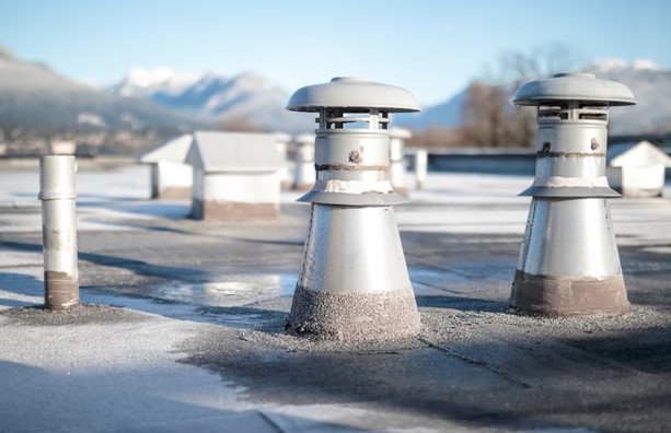 Three Metal Chimneys on a Snowy Roof Installed by Paul Bange Roofing in South Florida
