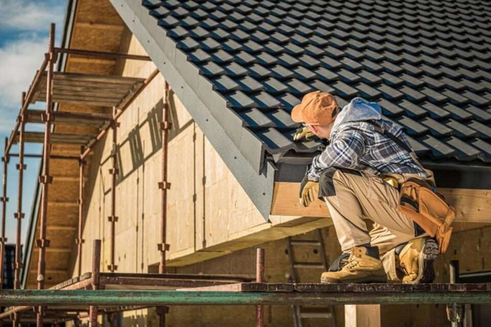 A man Is sitting on the roof's edge inspecting the roof in South Florida.